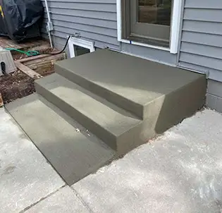 concrete patio stairs against house with siding